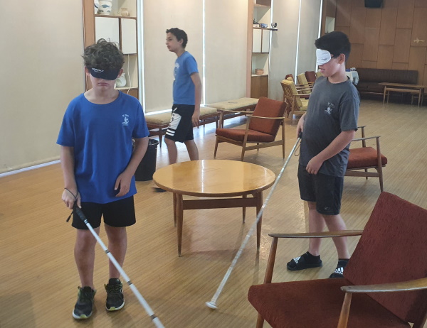 בני הנוער מתנסים בהליכה עם מקל נחייה